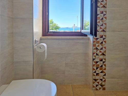 a bathroom with a toilet and a window at Terrazza Vista Lago in Capodimonte