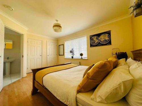 1 dormitorio con 1 cama grande y paredes amarillas en Astor house Maidstone long stay, en Maidstone