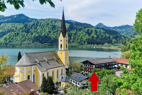 een grote gele kerk met een rode pijl die naar een stad wijst bij Ferienwohnung Auszeit am See in Schliersee