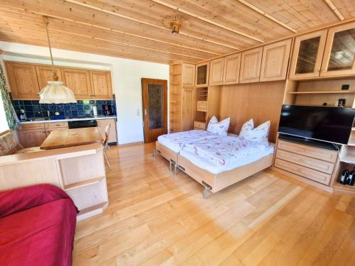 1 dormitorio con 1 cama en una habitación con armarios de madera en Ferienwohnung Auszeit am See, en Schliersee