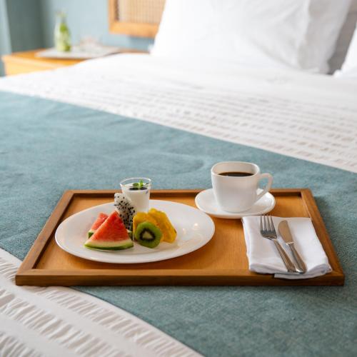 a tray with a plate of food and a cup of coffee at Jama Campay - Homes Resort & Spa in Jama