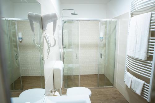 a bathroom with a glass shower and a toilet at Elixír Panzió in Nyírbátor