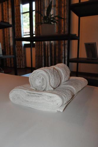 una pila de toallas sentadas sobre una mesa en Timber Guest House en Berat