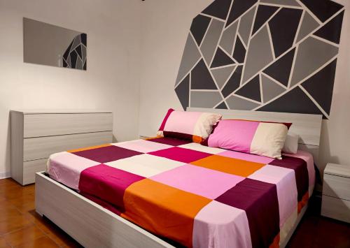 um quarto com uma cama colorida num quarto em Stabia House em Parma