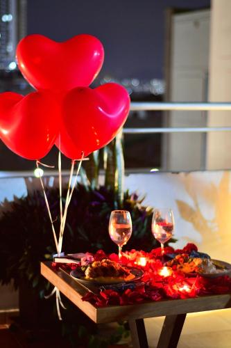 a table with red hearts balloons and wine glasses at Hotel Buena Vista Express in Bucaramanga