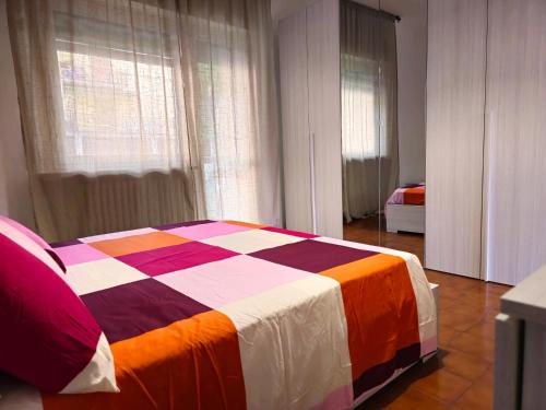 Un dormitorio con una cama con una manta de colores. en Stabia House, en Parma