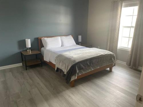 布盧明頓的住宿－Beautiful 3 BR Townhome - Recently Updated!，一间卧室配有一张床、两盏灯和一个窗户。