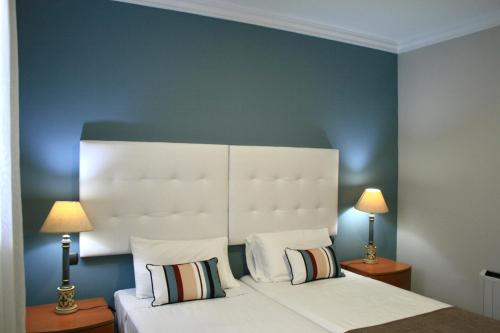 a bedroom with a bed with a white headboard and two lamps at Las Canteras Beach in Las Palmas de Gran Canaria