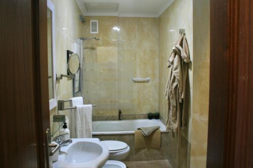 een badkamer met een wastafel, een toilet en een bad bij Las Canteras Beach in Las Palmas de Gran Canaria