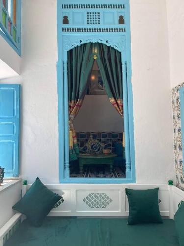 a living room with a mirror and a couch at Dar Lella Hasna in Sfax