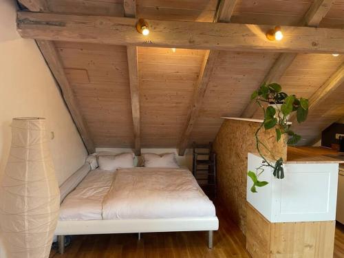a bed in a room with a wooden ceiling at Sonnige Ferienwohnung Maja in Heroldsberg