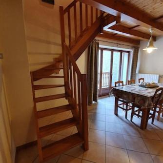 a wooden staircase in a living room with a table at L´ouillon in Lanslebourg-Mont-Cenis