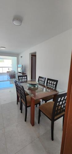 a dining room with a wooden table and chairs at Vista espectacular 180° Murano Praia do Morro in Guarapari