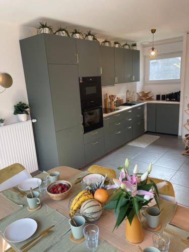 a kitchen with a table with fruits and vegetables on it at Villa des Cerisiers in Saint-Nazaire