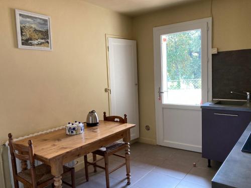 a kitchen with a wooden table and a window at Métairie de Moutiques in Cazaubon