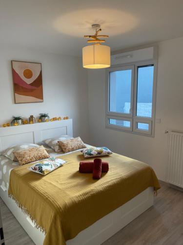 - une chambre avec un grand lit et une couverture jaune dans l'établissement Villa des Cerisiers, à Saint-Nazaire