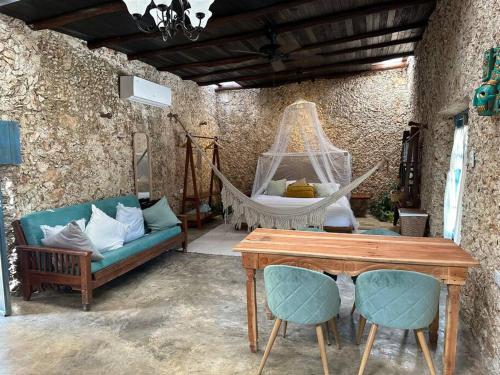 a room with a hammock and a couch and a table at Cenotefront House 20 min from Chichen Casa Yaxunah 