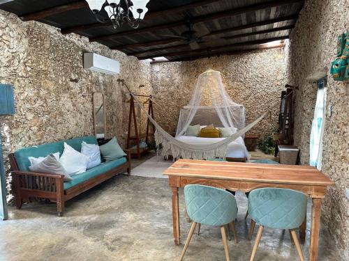 a room with a hammock and a couch and a table at Casa Yaxunah in Yaxuná