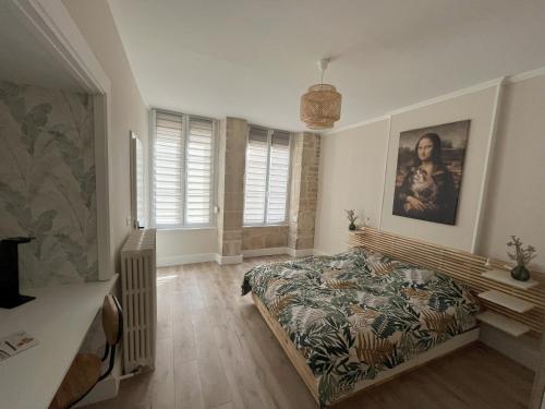 a bedroom with a bed and a painting on the wall at La Cour du Prince in Verdun