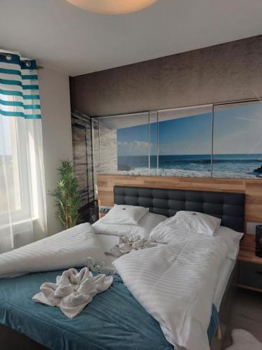 a bedroom with a large bed with a view of the ocean at Happiness Apartman in Kecskemét