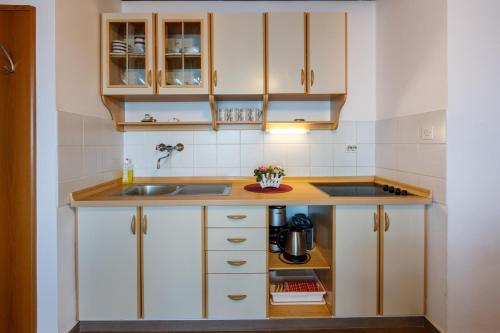 a small kitchen with white cabinets and a sink at Apartmani Višnja in Crikvenica