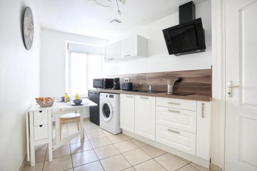 une cuisine blanche avec un évier et un lave-vaisselle dans l'établissement Le Cherbourg - Second Souffle - Cherbourg, à Cherbourg en Cotentin