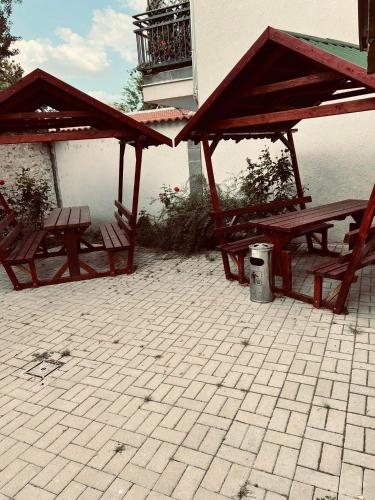 two picnic tables and benches under a pavilion at Best Price Guesthouse in Szeged