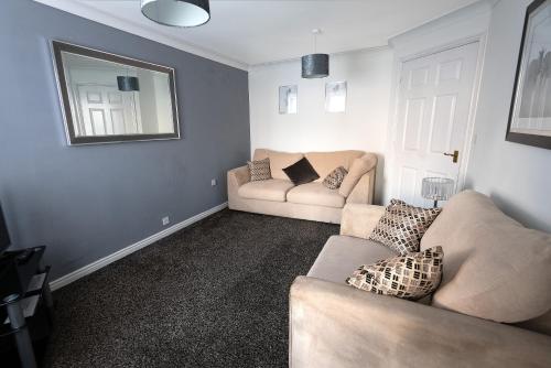 a living room with two couches and a mirror at Witton House in Stockton-on-Tees