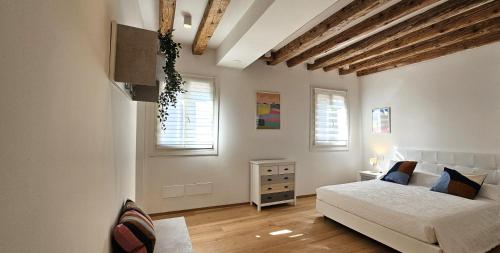 a bedroom with a bed and a dresser and two windows at Cozy Small Villa with Private Garden in Venice