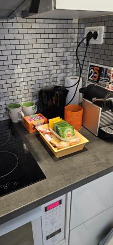 - un comptoir avec un plateau de nourriture dans l'établissement STUDIO 22M2 A IVRY/SEINE-A 200 METRES DE PARIS. PROCHE METRO 7, à Ivry-sur-Seine