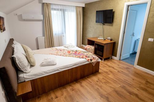 a hotel room with a bed and a television at Sole Boutique in Râmnicu Vâlcea