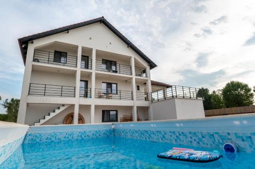 a house with a swimming pool in front of a building at Sole Boutique in Râmnicu Vâlcea