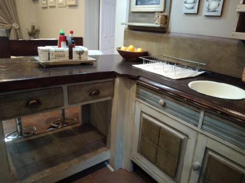 a bathroom with a sink and a counter with a sink at Rubyred Cottage in Bloemfontein