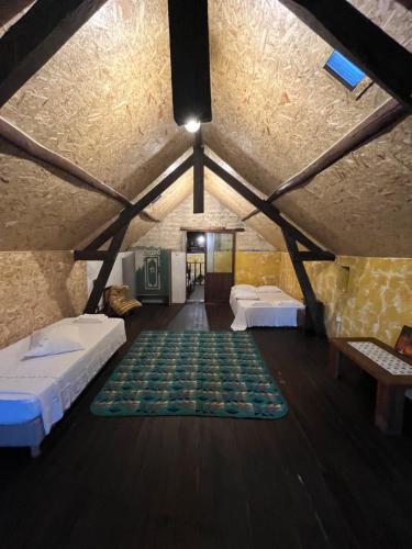 an attic room with two beds and a green rug at AVEIRO MAIAS VILLAGE - CASA DO ÁLVARO in Oliveirinha