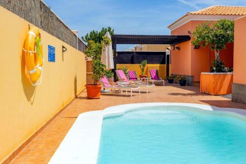 - une piscine dans une cour avec des chaises et une maison dans l'établissement Villa Playa (Los Cristianos), à Los Cristianos