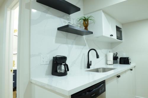 a white kitchen with a sink and a counter top at Spacious 2-Bed-Room near Yonge & Major Mackenzie in Richmond Hill