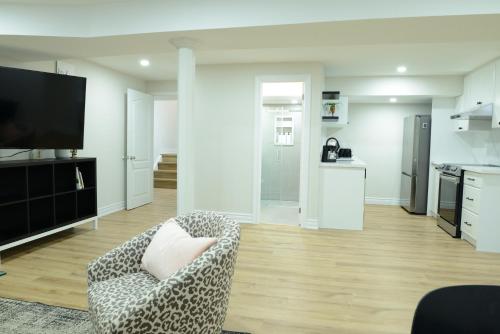 a living room with a chair and a kitchen at Spacious 2-Bed-Room near Yonge & Major Mackenzie in Richmond Hill