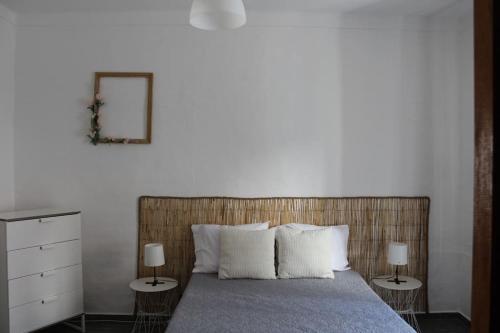 een slaapkamer met een bed met 2 nachtkastjes en 2 lampen bij Morgado Guest House in Ervedal