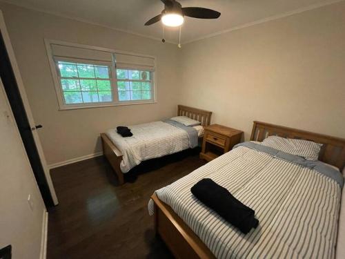 a bedroom with two beds and a window at Cute ranch house, less than 1 mile to downtown and skidmore. 2 miles to the track and SPAC in Saratoga Springs