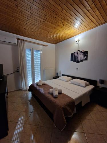 a bedroom with a large bed and a wooden ceiling at Villa Erofili Plakias south Rethimno Crete in Asómatoi