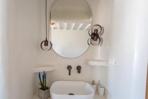 a bathroom with a white sink and a mirror at SEA SIDE APARTMENTS IN ORNOS BEACh in Ornos