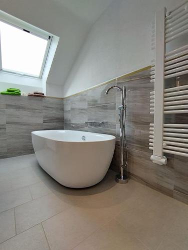 a large white tub in a bathroom with a window at Wolke7 in Frittlingen