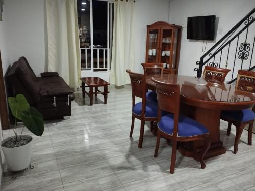 sala de estar con mesa de madera y sillas en Mi casa tu casa, en Santa Rosa de Cabal