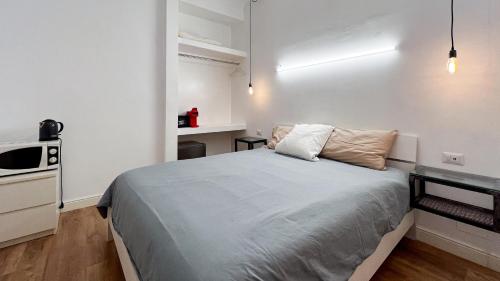 a small bedroom with a bed and a microwave at Chambre moderne, proche Monaco in Beausoleil