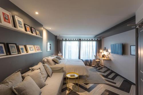 a bedroom with a bed and a couch at Q HOME_iconsiam in Khlong San