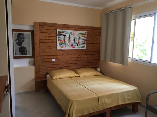 Schlafzimmer mit einem Bett mit einem Kopfteil aus Holz in der Unterkunft Beach Villa am Praia de Chaves, Sal Rei, Boa Vista in Boa Ventura