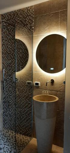 a bathroom with a sink and a glass shower at Dimora Cleó in Putignano