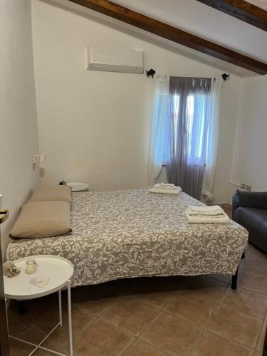 Dormitorio pequeño con cama y mesa en La casetta di Minnannu, en Palau