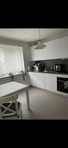 a kitchen with white cabinets and a table in it at Ein ruhiger Ort in Hamburg