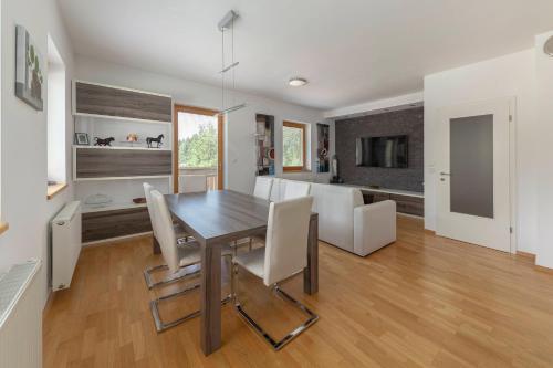 uma sala de jantar e cozinha com mesa e cadeiras em Sunee Apartment em Kranjska Gora